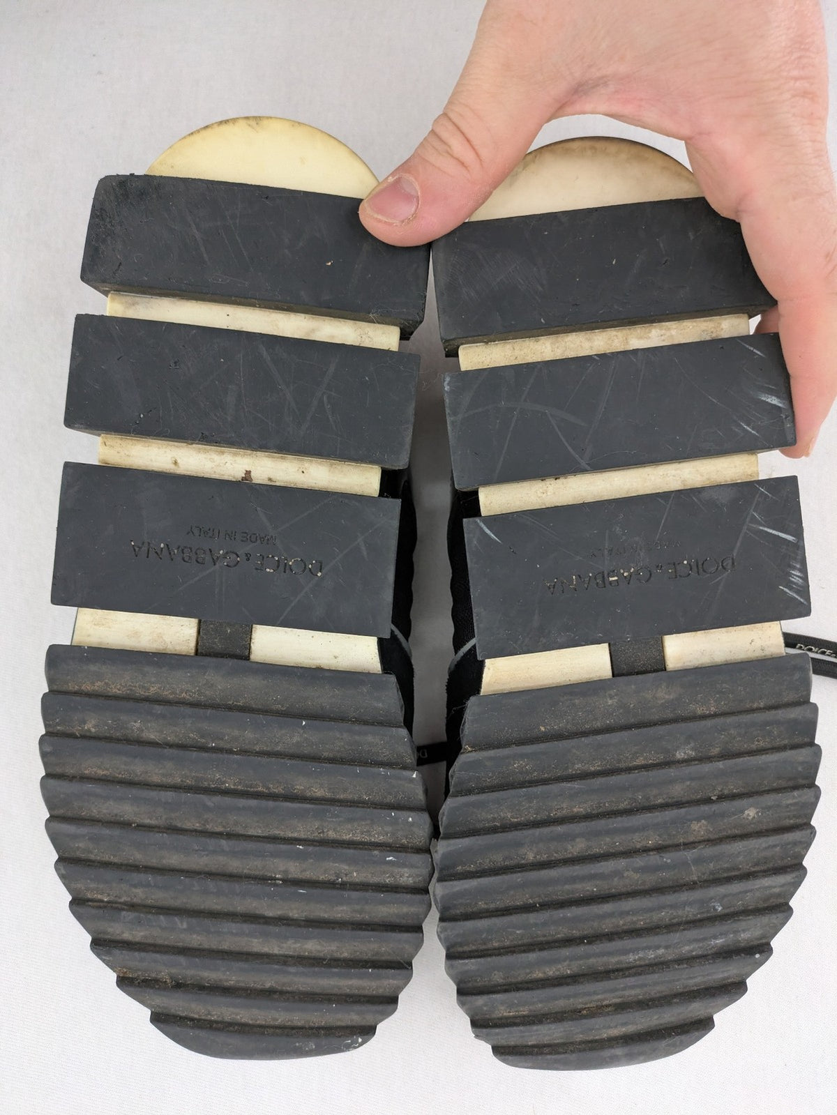 Dolce & Gabbana black sneakers with logo laces and segmented sole design.