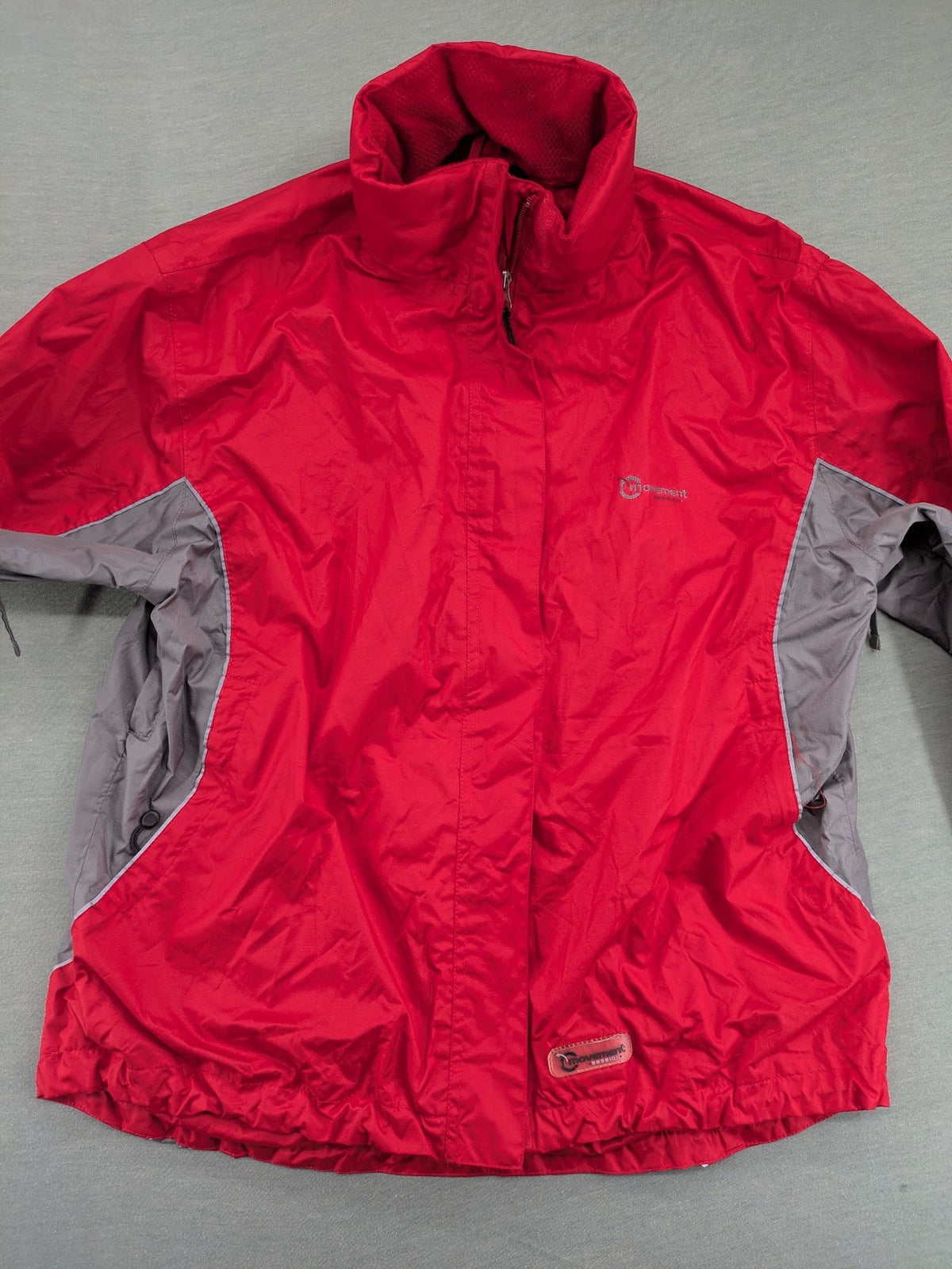 Movement Session grey and red windbreaker jacket with colorblock pattern and full zip.