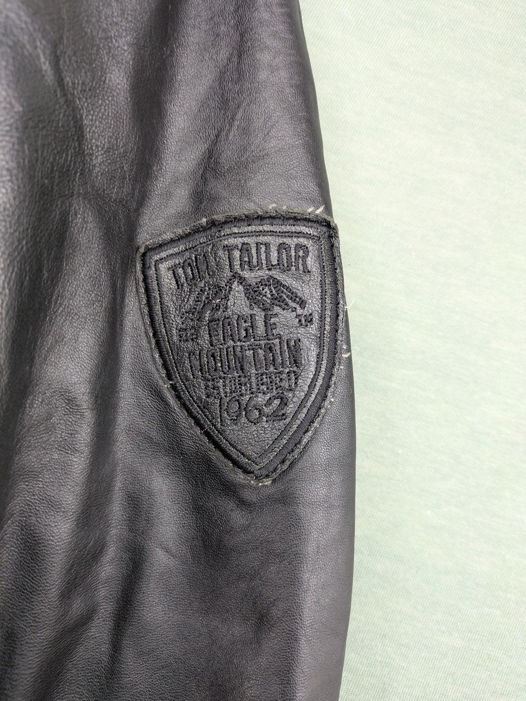 Tom Tailor black leather jacket vintage style with multiple pockets and contrast stitching.