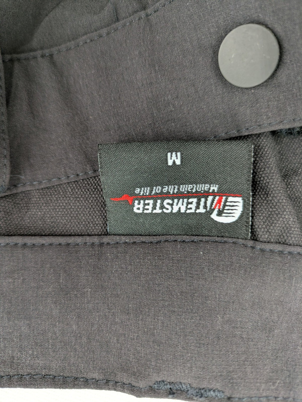 Outdoor black capri pants with elastic waistband and multiple zippered pockets.