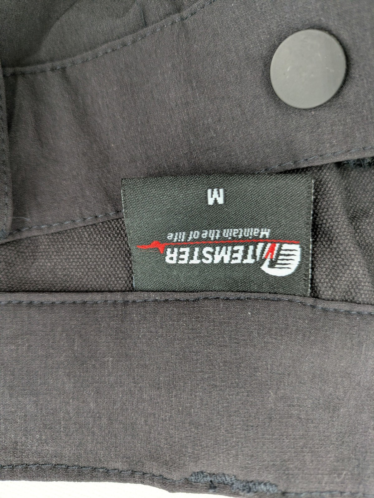 Outdoor black capri pants with elastic waistband and multiple zippered pockets.