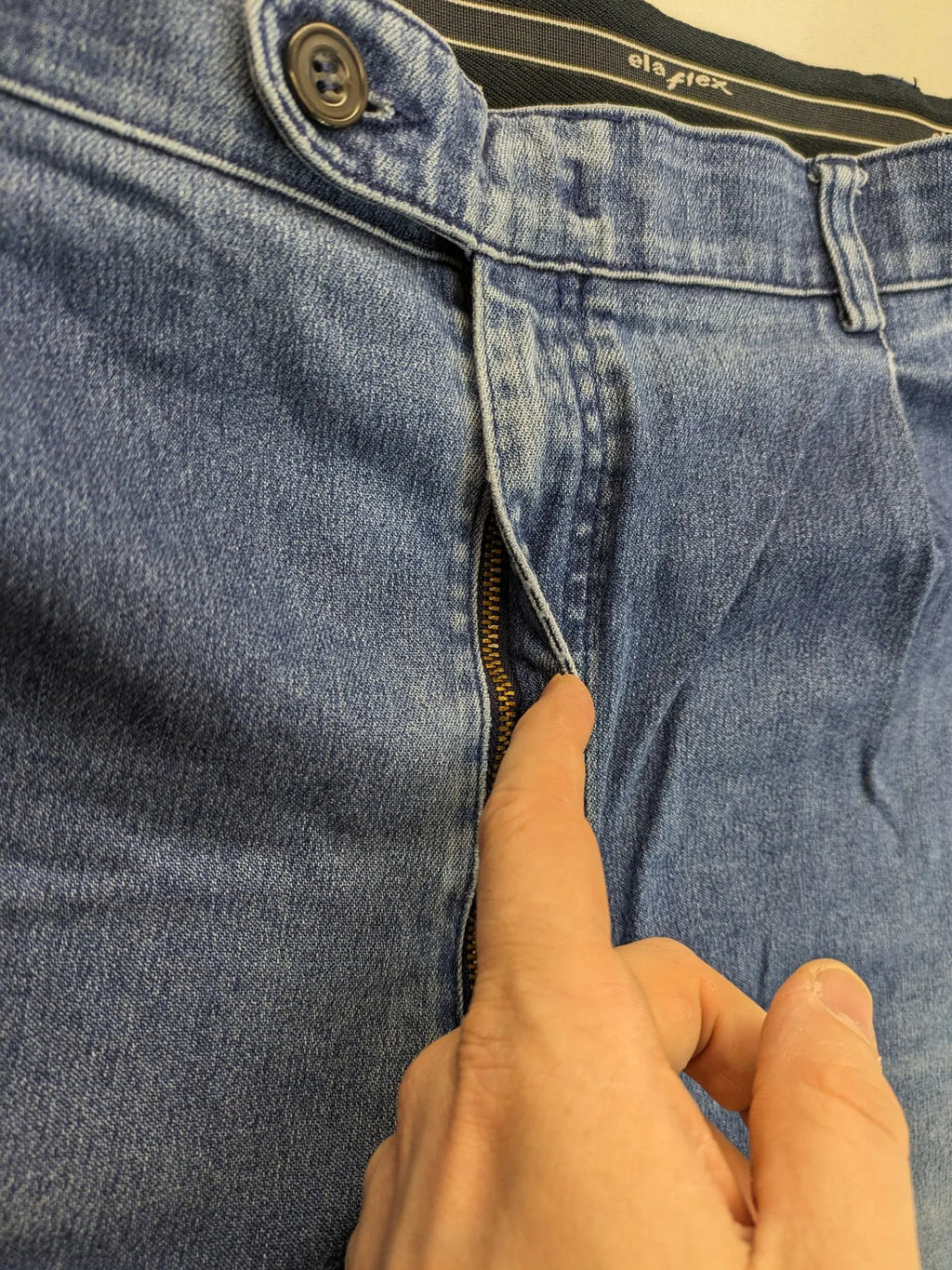 REI blue straight jeans with front pleats, zip fly, and buttoned back pockets.