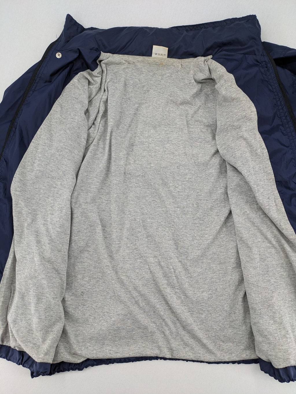 Fila navy windbreaker jacket with large embroidered logo on chest and back.