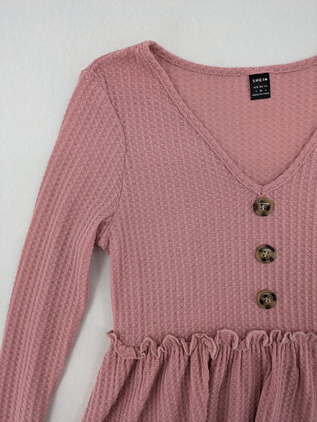 SHEIN pink top V-neck with ruffled waist and three decorative buttons, waffle knit fabric.