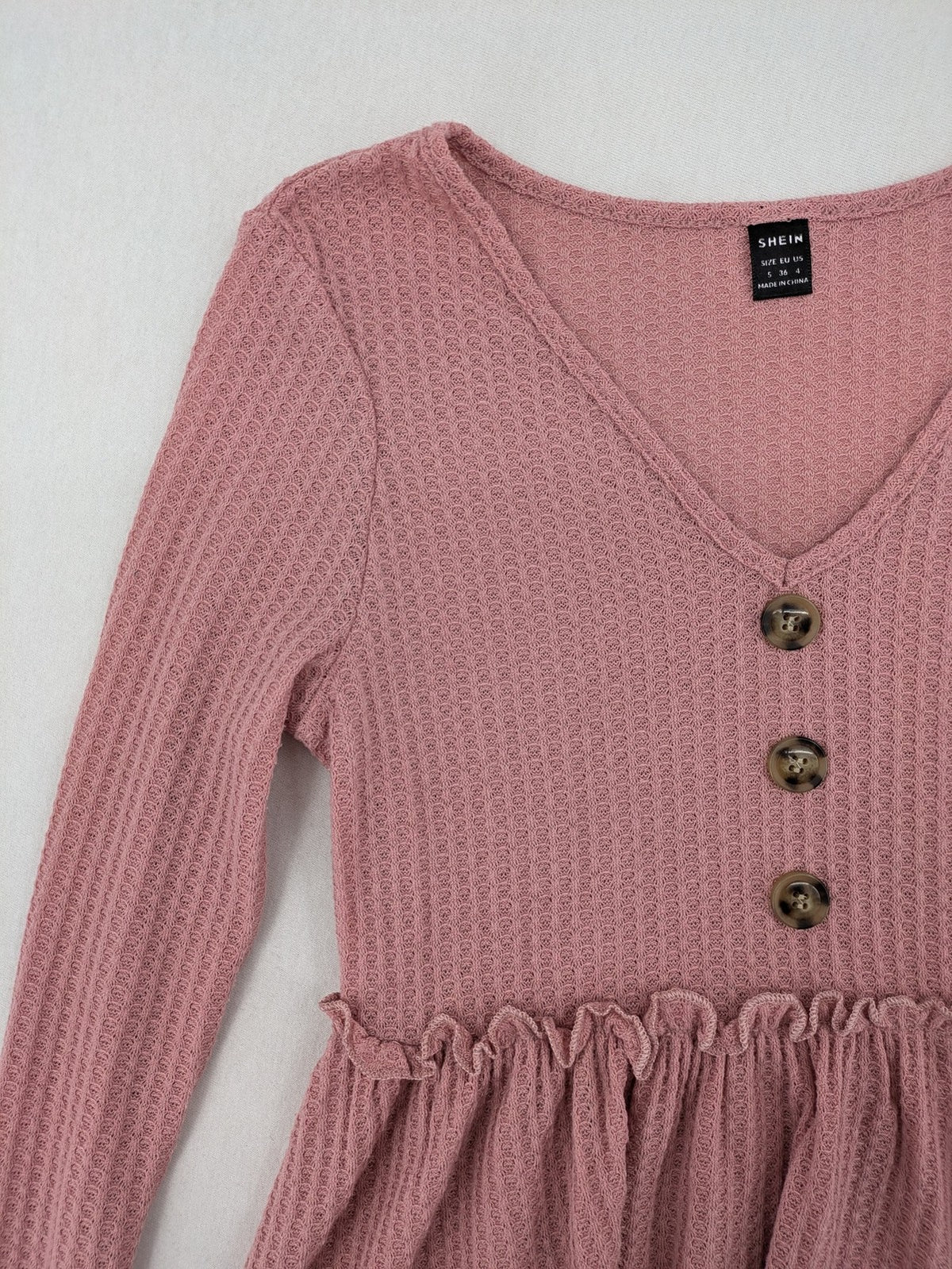 SHEIN pink top V-neck with ruffled waist and three decorative buttons, waffle knit fabric.