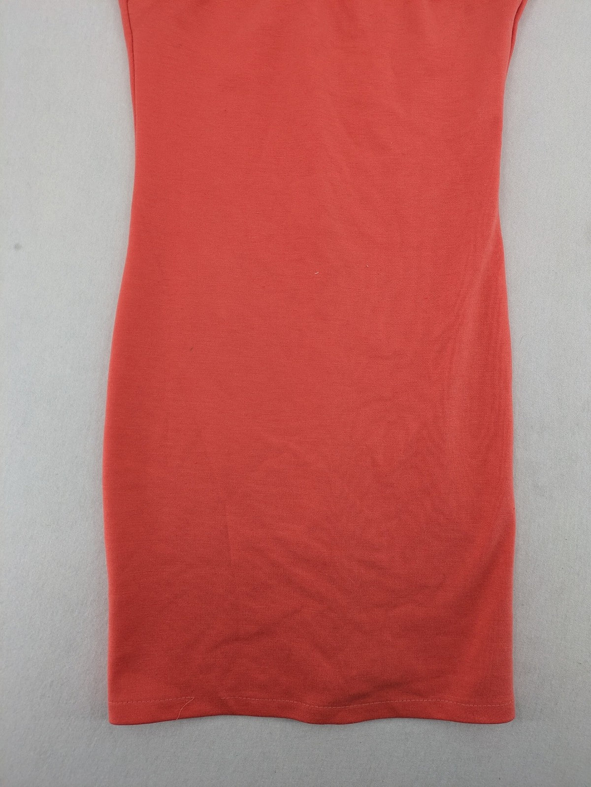 Zebra orange bodycon mini dress with deep V-neck and sleeveless design.