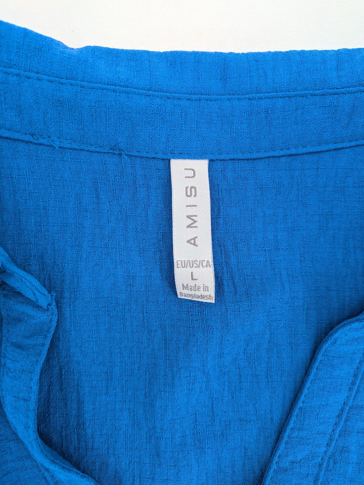 Amisu blue sleeveless blouse with classic collar, button placket, and high-low hem.