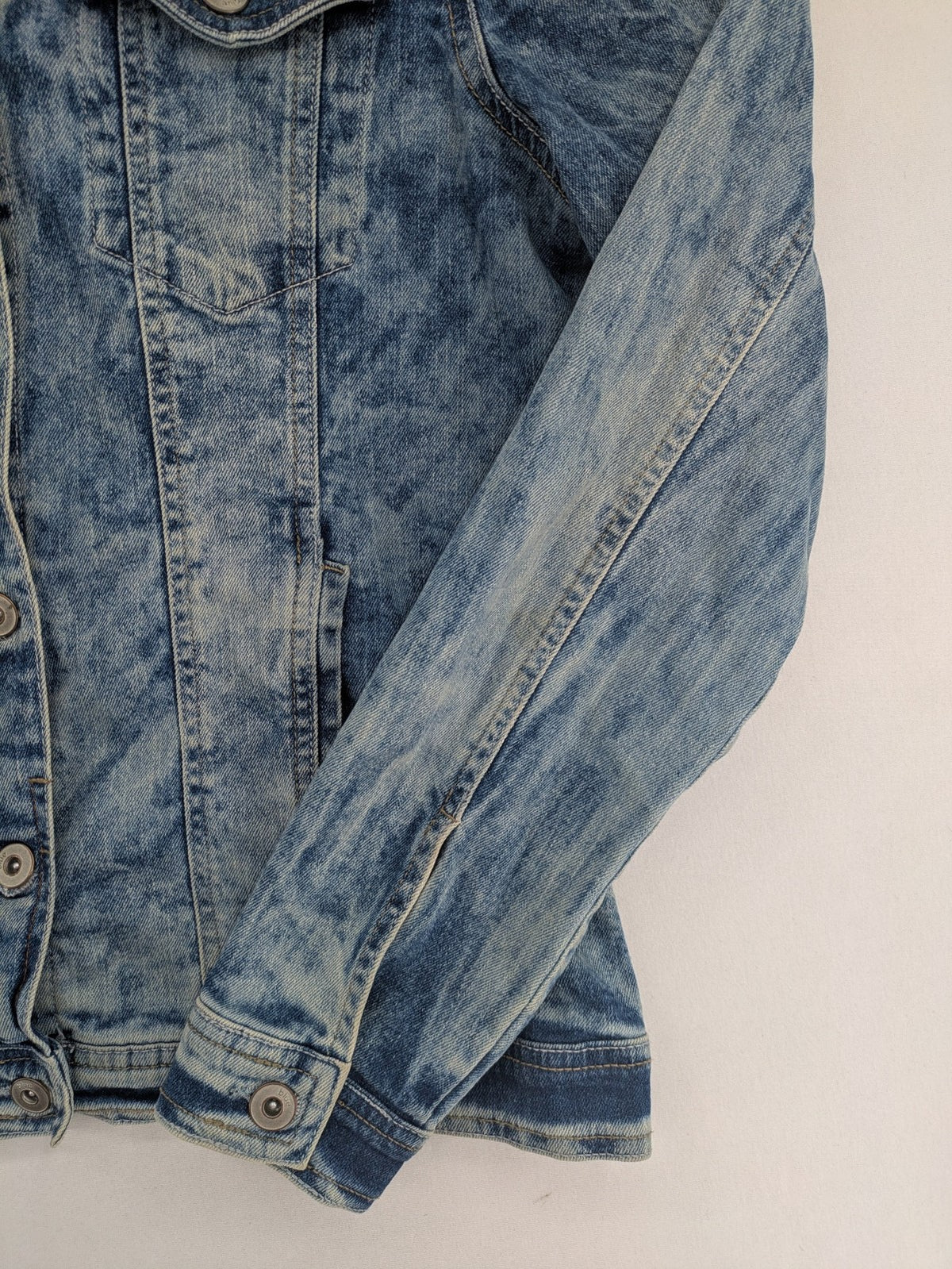 Baumwolle blue denim trucker jacket acid wash with button closure and chest pockets.