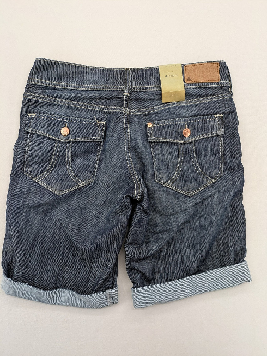 H&M blue denim shorts with rolled cuffs and back patch pockets, mid-rise fit.