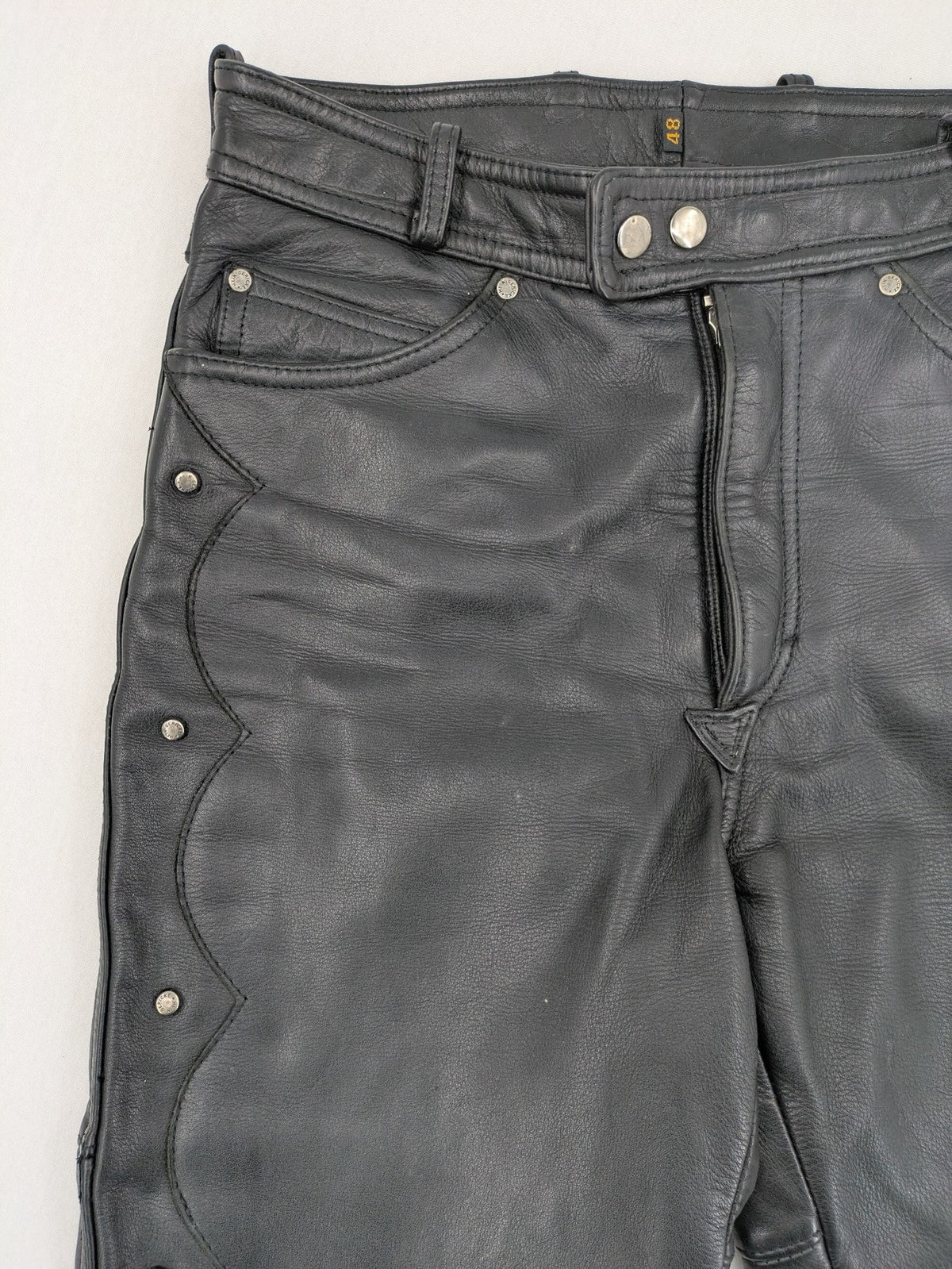 Hein Gericke black leather chaps with studs and wavy decorative seams.