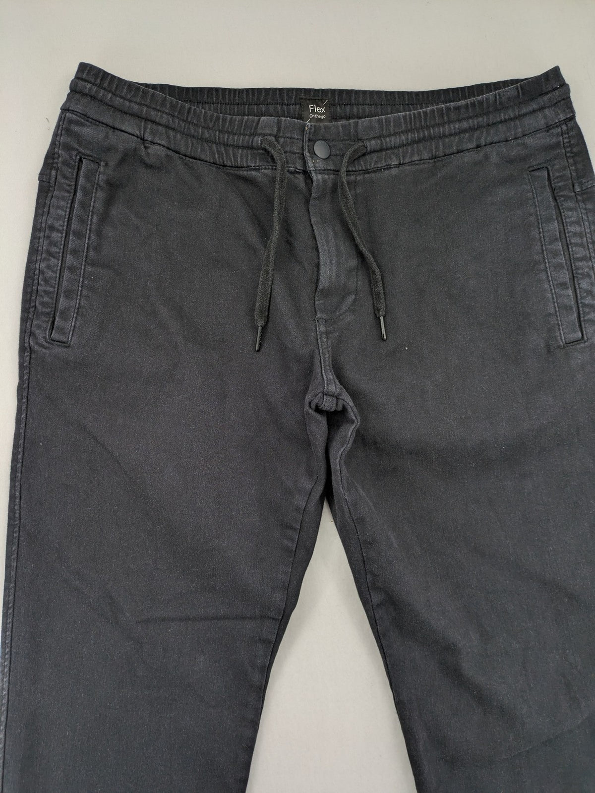 C&A grey jogger pants with elastic cuffs, drawstring waist, and multiple pockets.