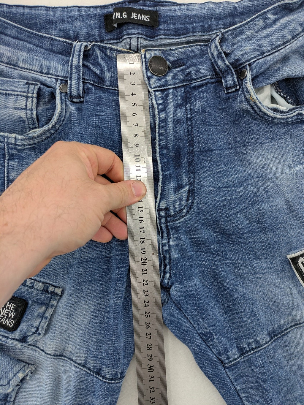 FN.G blue straight jeans with AC/DC patch, smiley face, and elastic jogger cuffs.