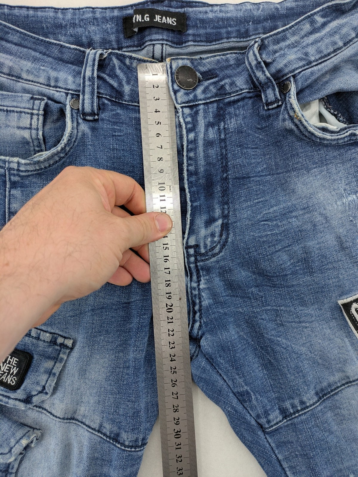 FN.G blue straight jeans with AC/DC patch, smiley face, and elastic jogger cuffs.