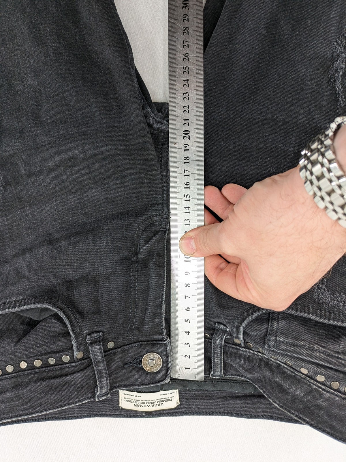 Zara Woman black skinny jeans with distressed details, silver studs, and frayed hem.