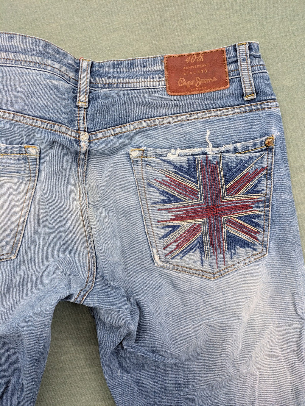 Pepe Jeans blue straight jeans with Union Jack embroidery and distressed denim finish.
