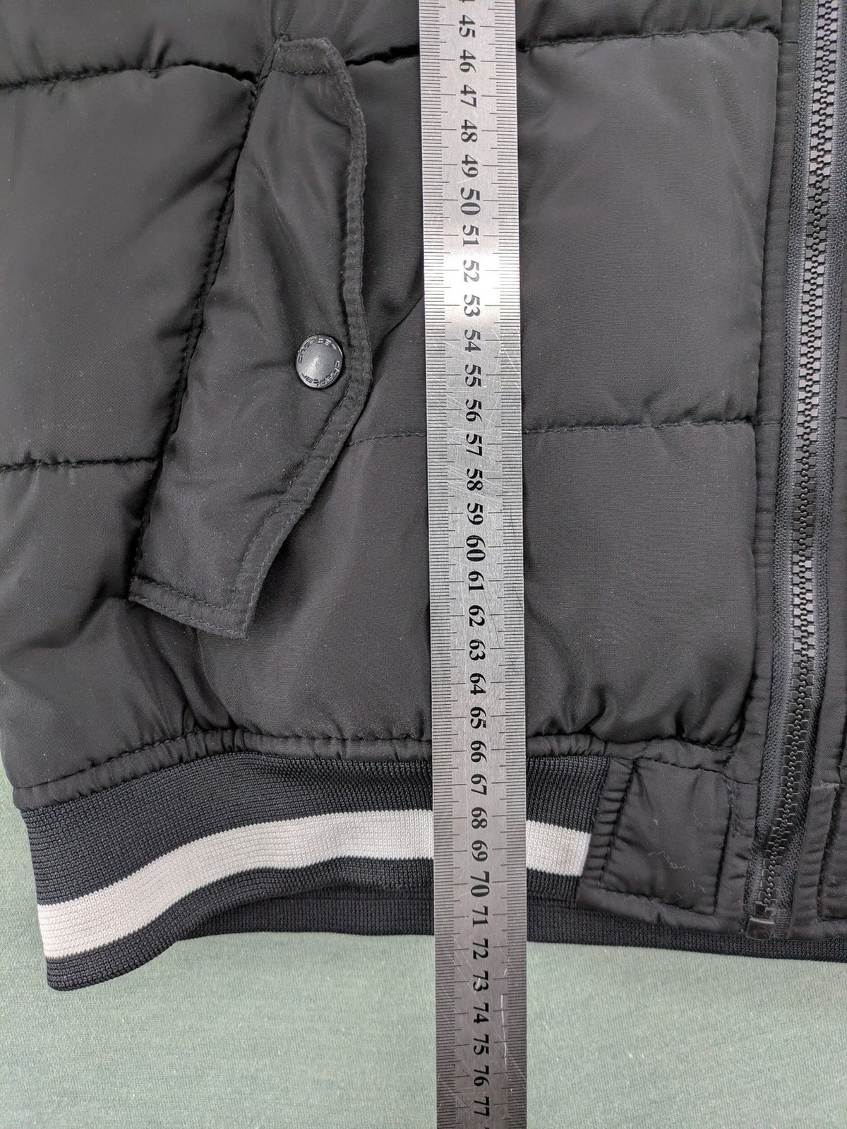 Chapter black bomber jacket with patches, striped ribbed cuffs, and full zip closure.