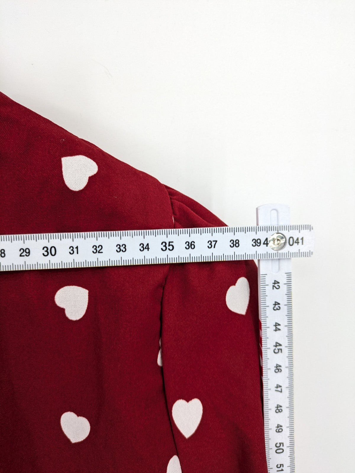 SHEIN burgundy top with white heart pattern and ruffled neckline detail.