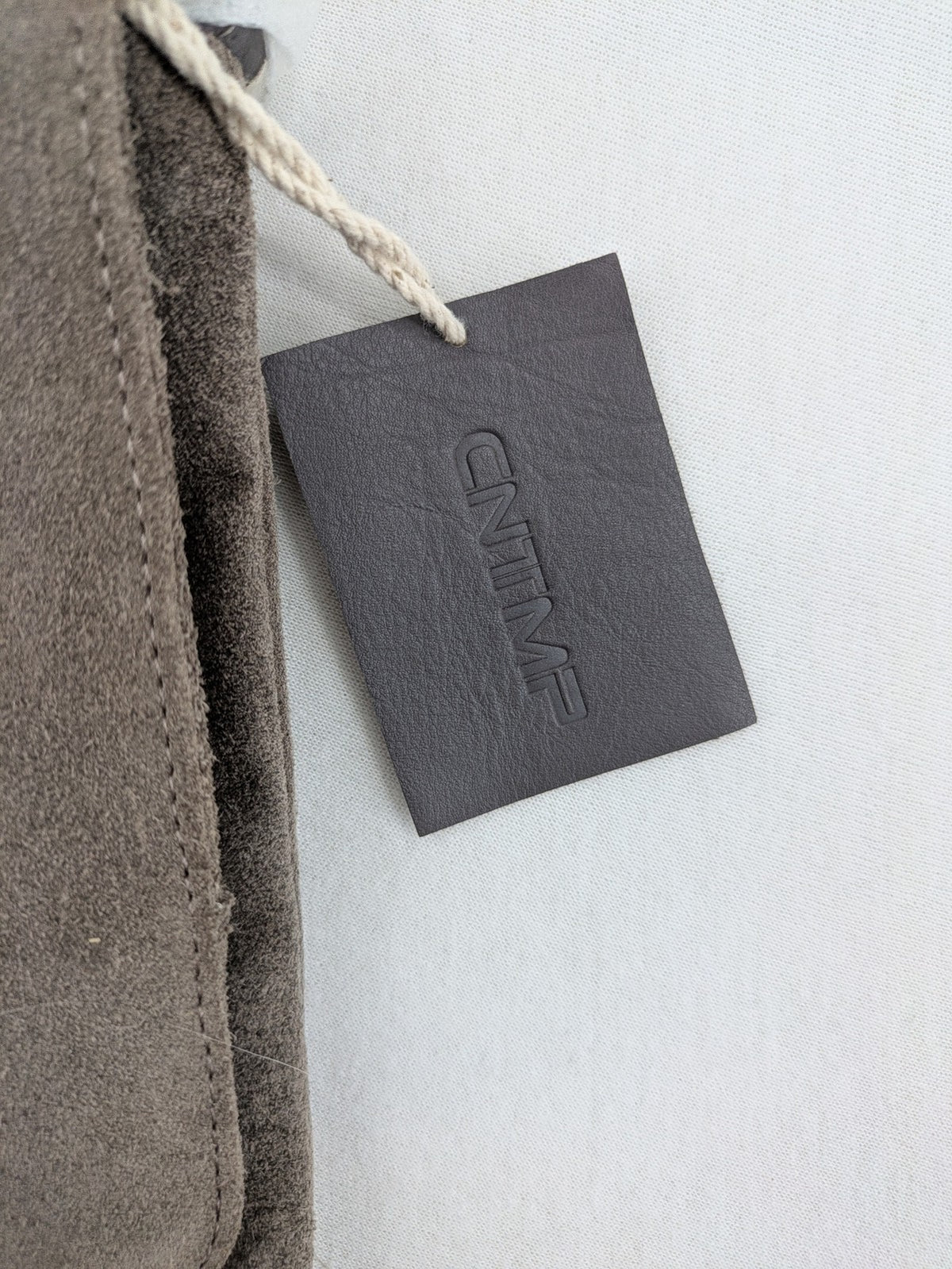 CNTMP grey suede crossbody handbag with flap and silver twist lock closure.