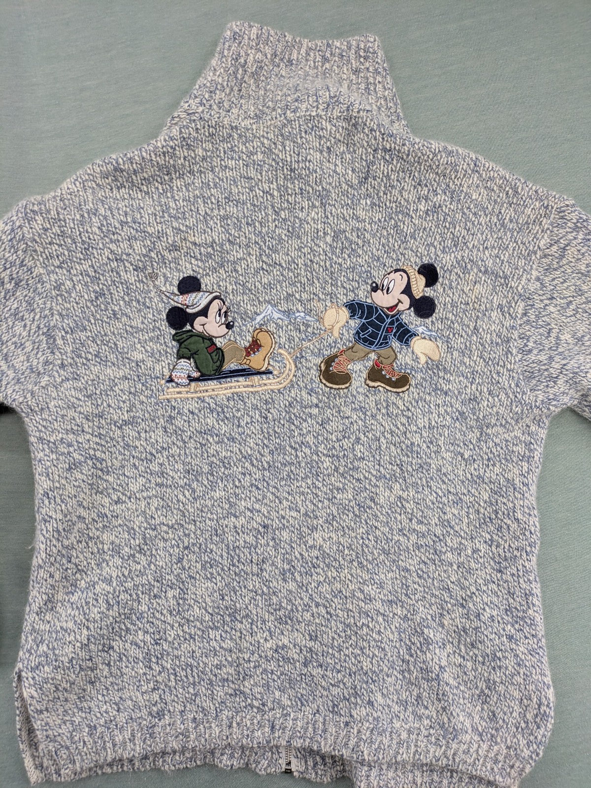Disney blue turtle neck jumper with grey Mickey and Minnie Mouse embroidery, zip closure.