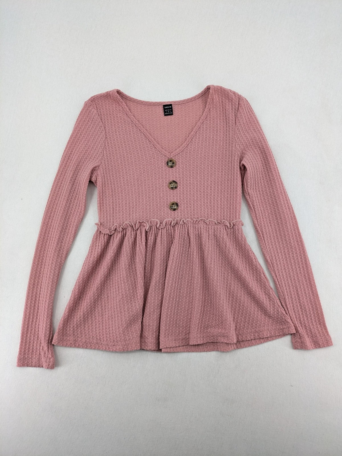 SHEIN pink top V-neck with ruffled waist and three decorative buttons, waffle knit fabric.