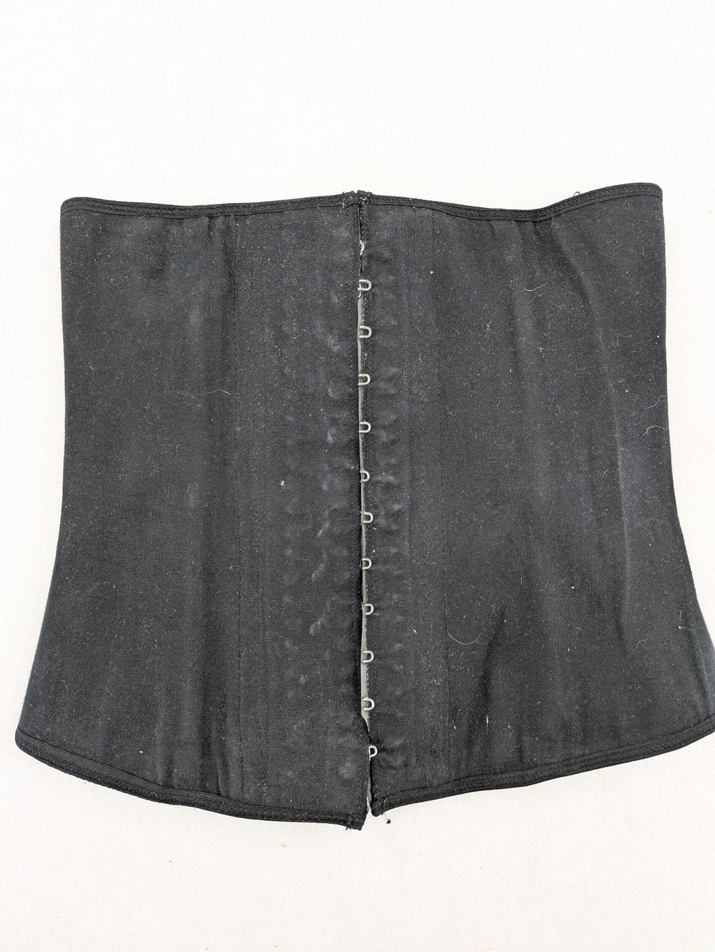 Faja black shapewear body shaper with multiple hook-and-eye closures and latex core.