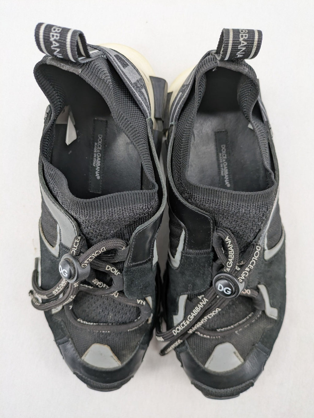 Dolce & Gabbana black sneakers with logo laces and segmented sole design.