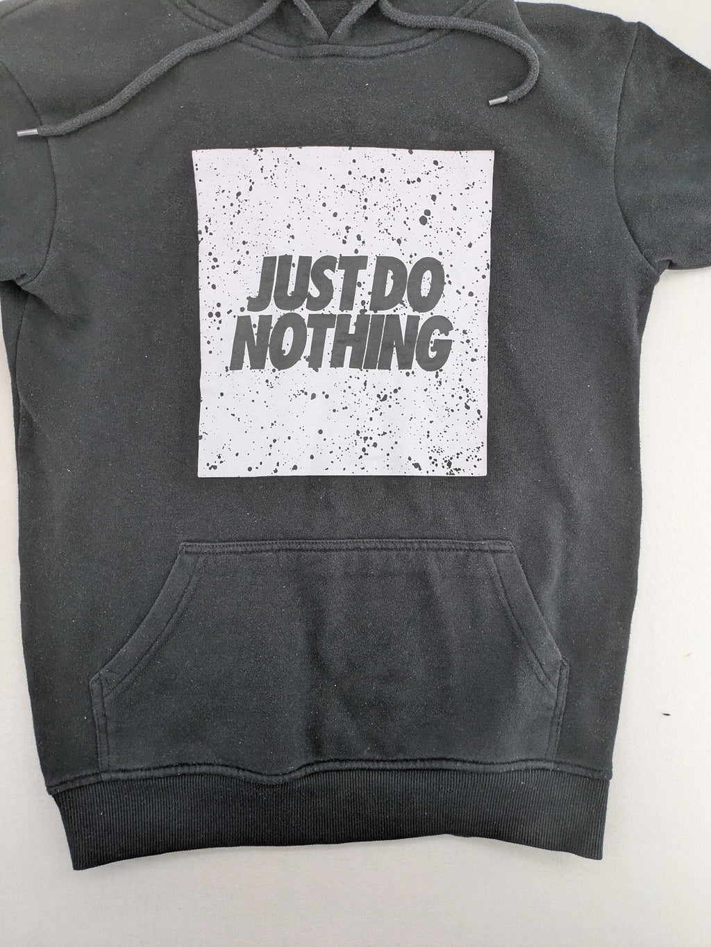FSBN white zip-through hoodie with "Just Do Nothing" graphic and adjustable drawstring hood.