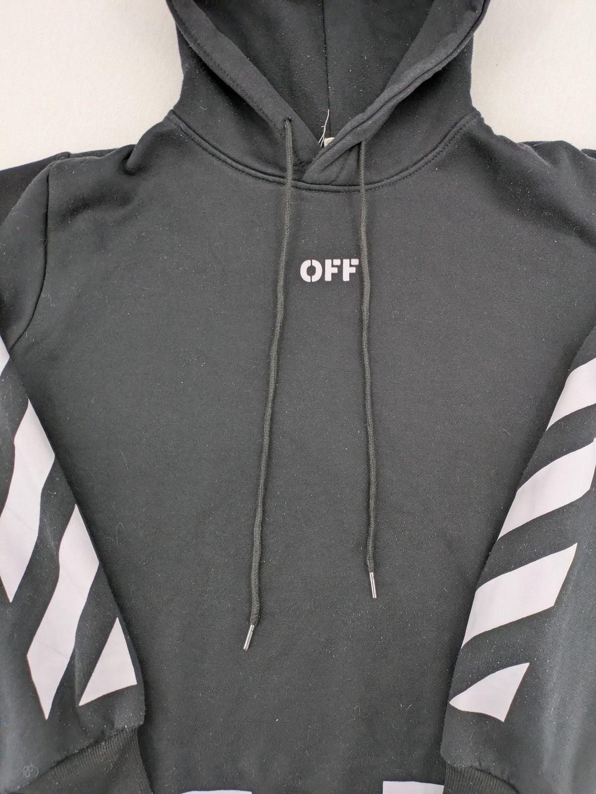 Off-White white zip-through hoodie with diagonal stripes and large arrows graphic.