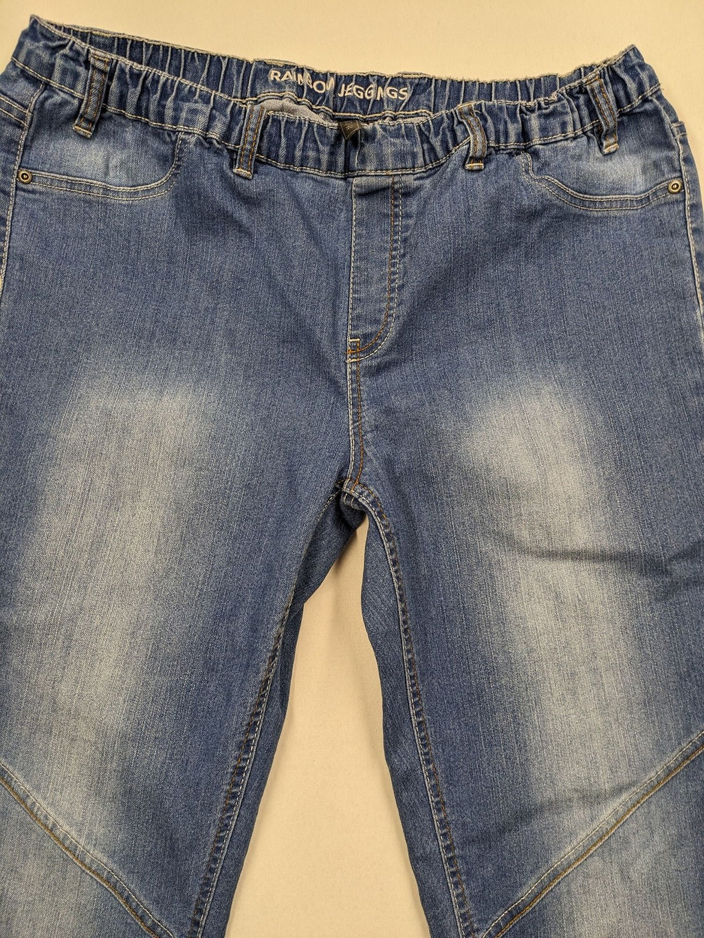 Rainbow blue straight jeans with elastic waistband and decorative knee stitching.