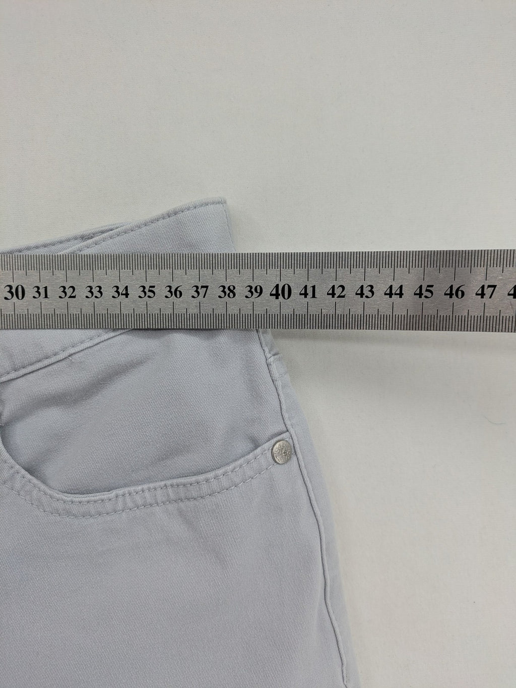Chino grey capri pants five-pocket design with subtle embroidery and stretch cotton blend.
