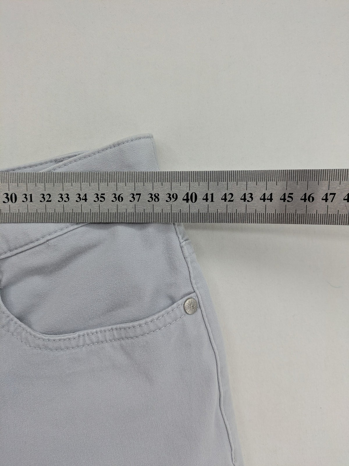 Chino grey capri pants five-pocket design with subtle embroidery and stretch cotton blend.
