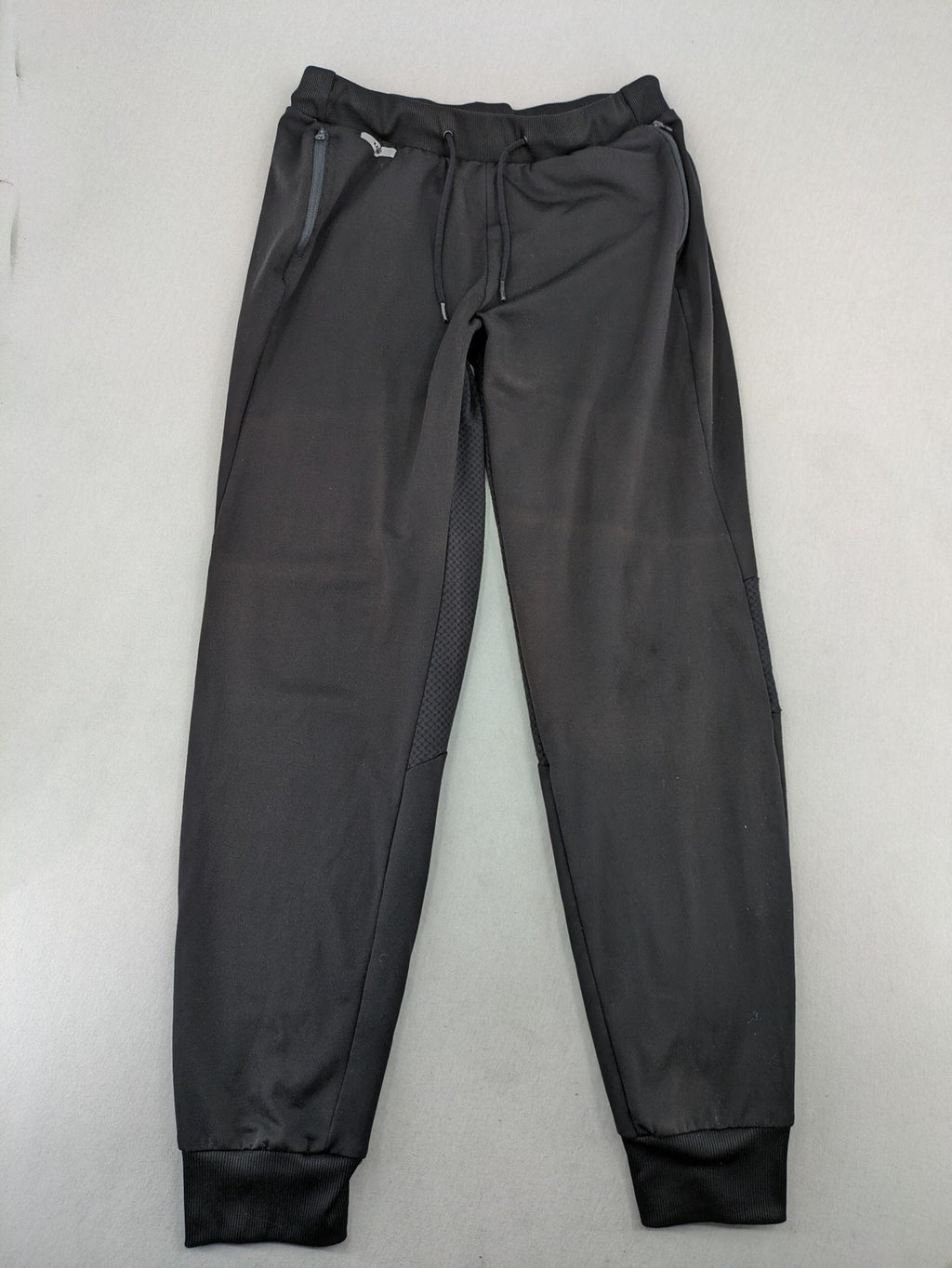 Kalenji black loungewear pants with grey accents and zippered side pockets.