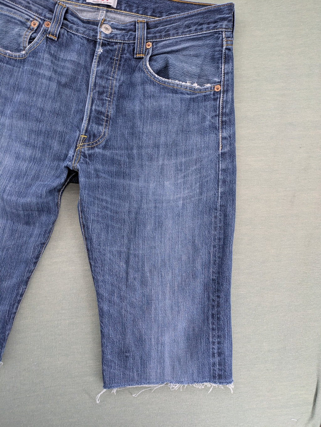Levi's blue cut-off shorts with frayed hem, classic 5-pocket design, button fly.