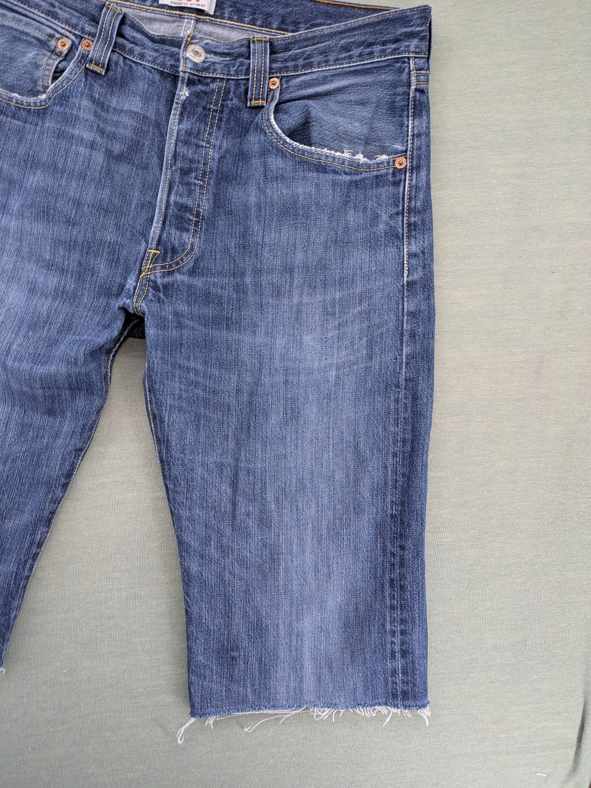 Levi's blue cut-off shorts with frayed hem, classic 5-pocket design, button fly.