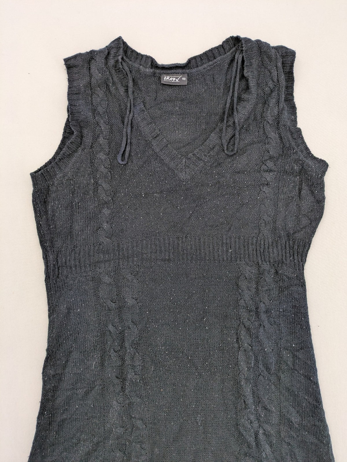 Okay black sleeveless dress V-neck with decorative cord and cable knit pattern.