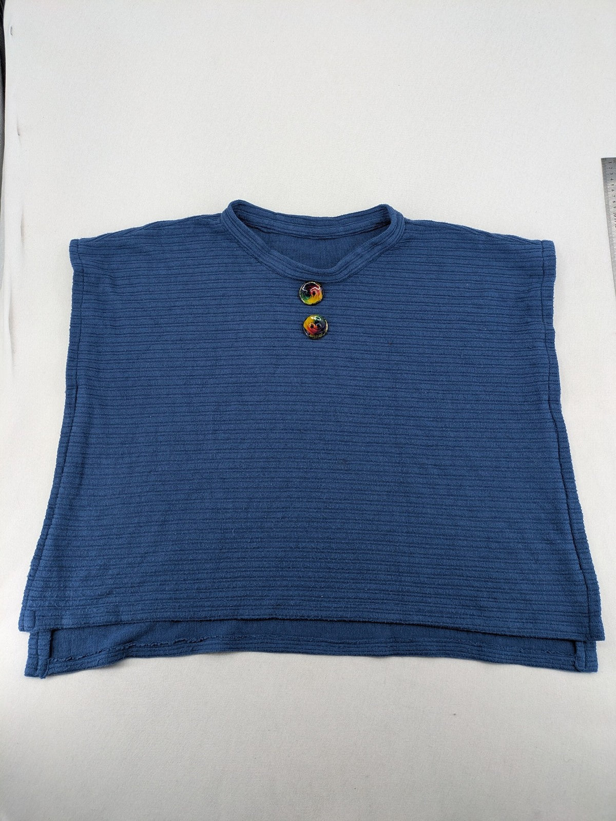 Secondhand blue tank top with ribbed texture and colorful decorative buttons.