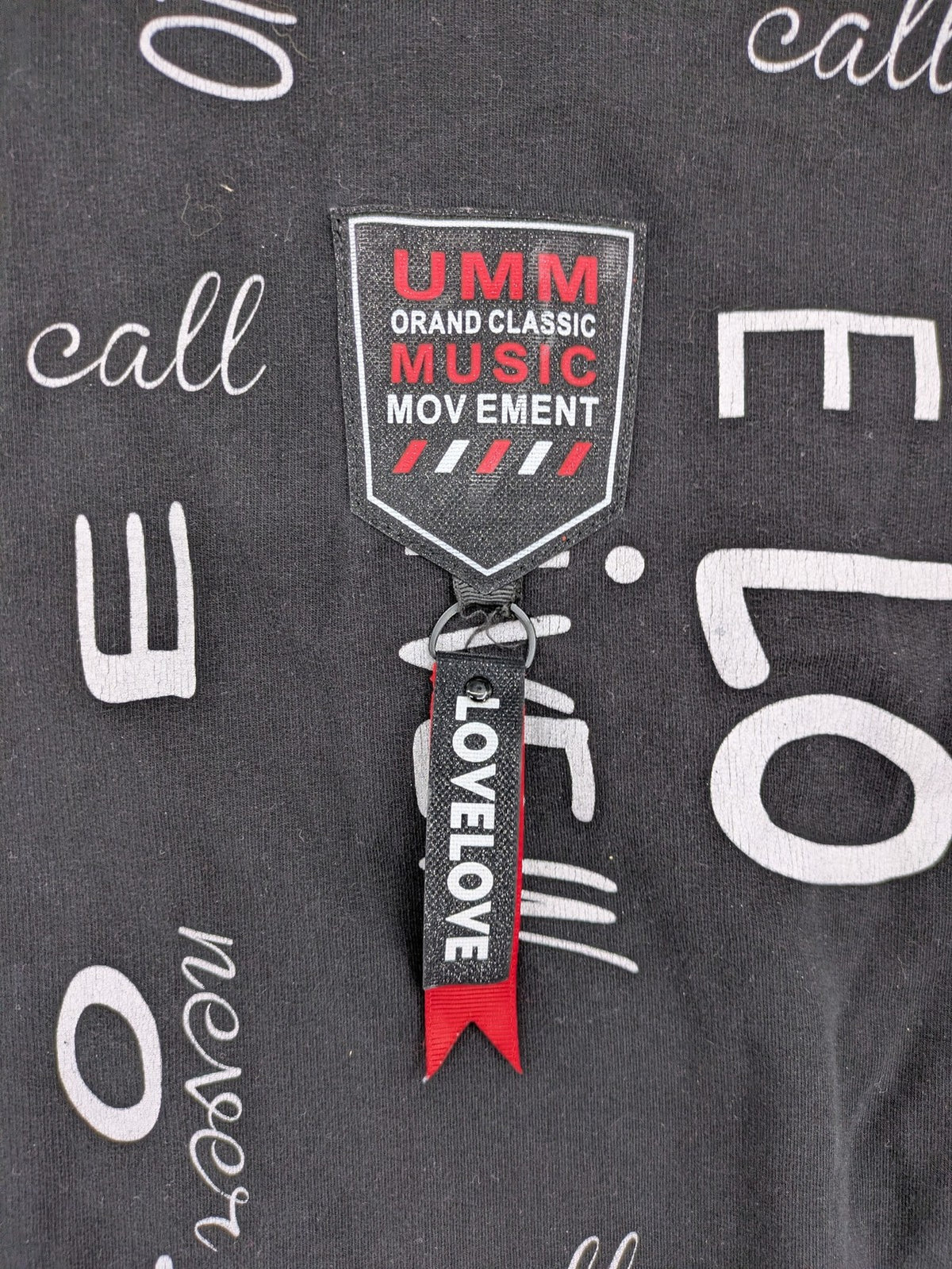 MEGI Collection black hoodie dress with graphic print and asymmetrical high-low hem.