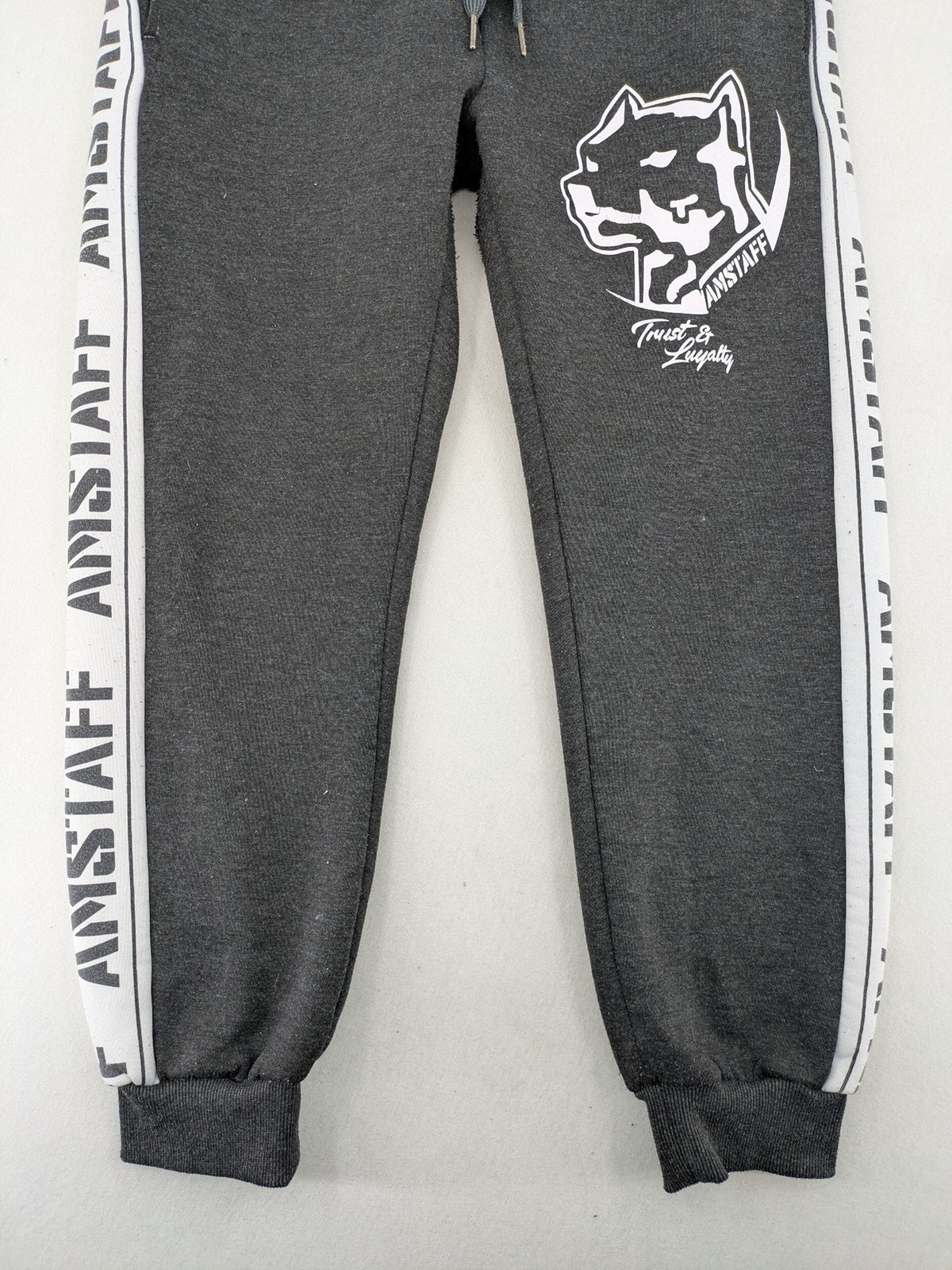 Amstaff grey sweatpants with large dog logo and "Trust & Loyalty" text.
