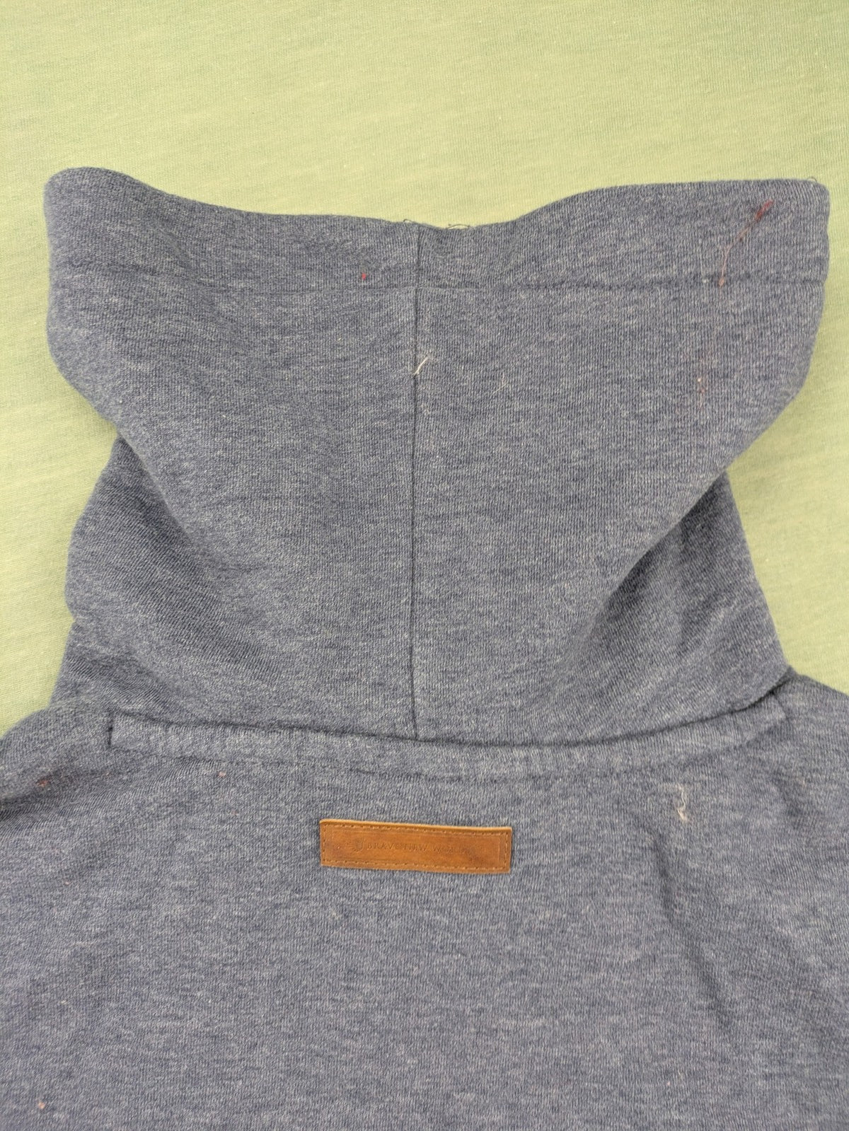 Naketano grey turtle neck jumper with thick drawstring and leather logo appliqué.