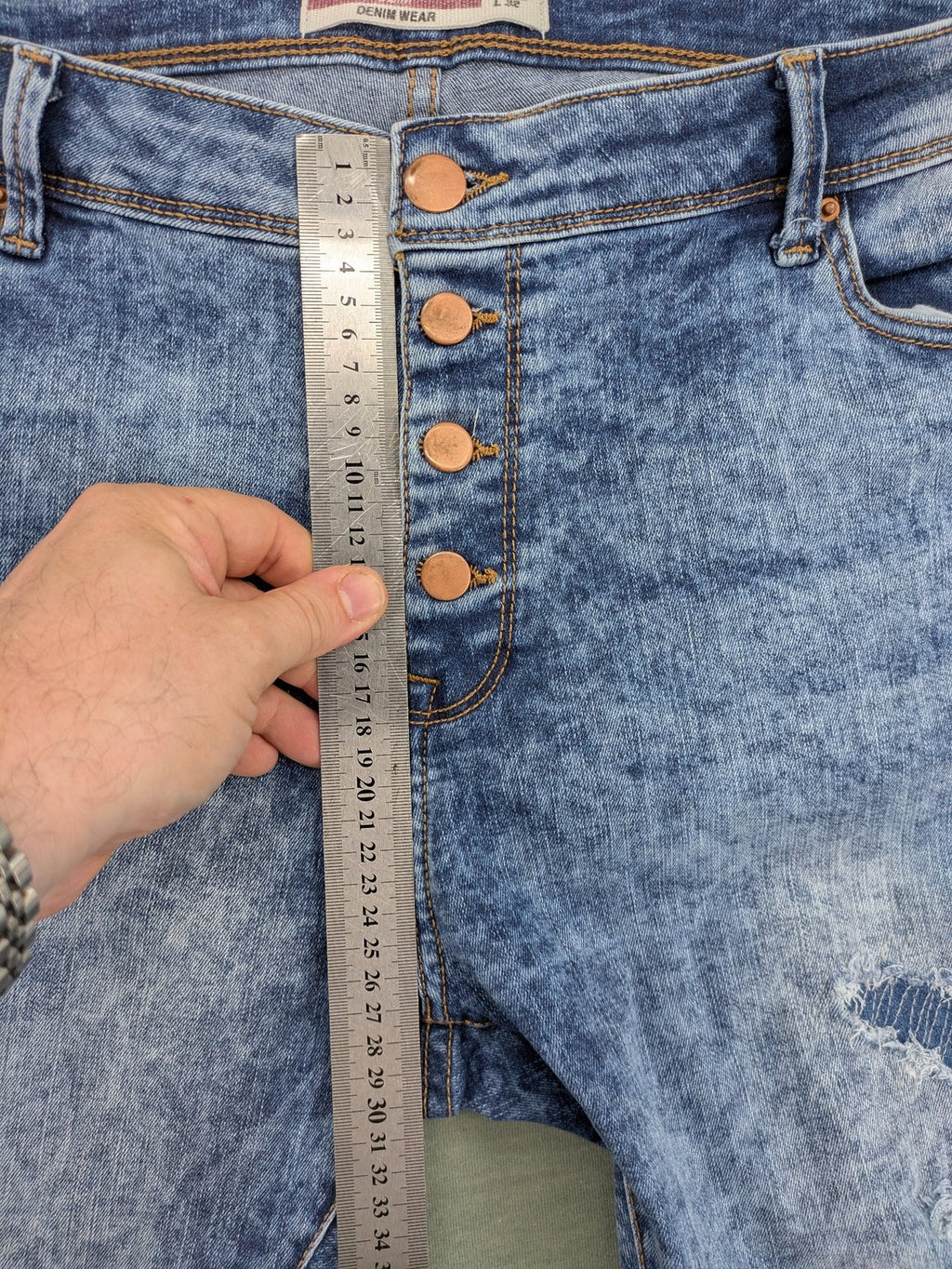 Janina blue slim fit jeans with acid wash, destroyed details, and button fly.