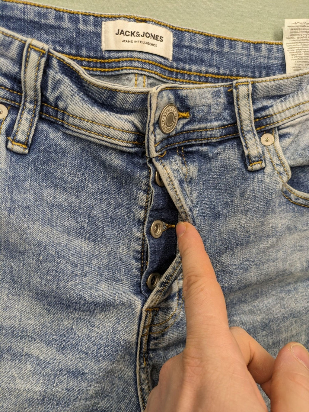 Jack & Jones blue slim fit jeans with button fly and light wash denim texture.