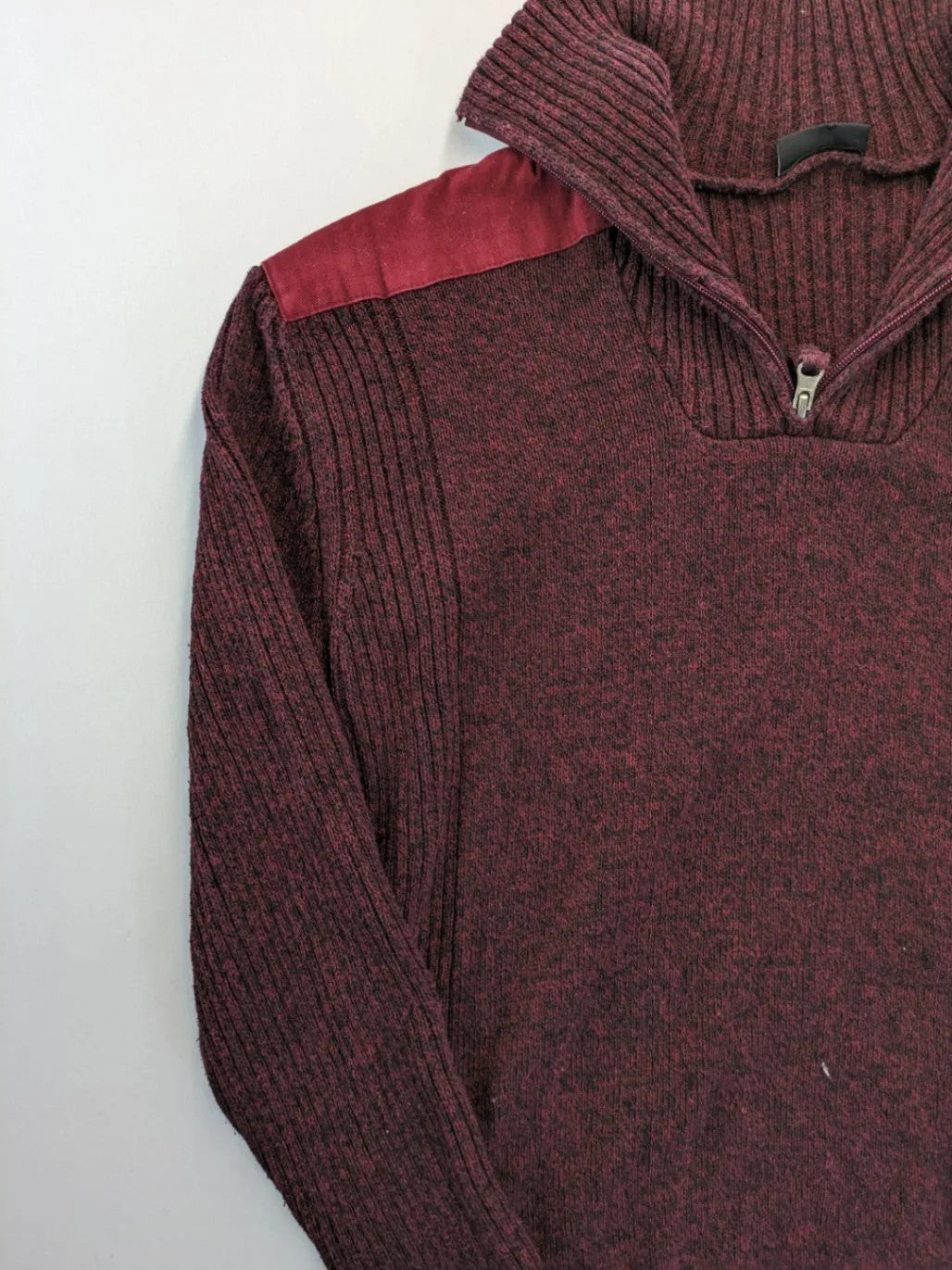 Infinity burgundy turtle neck jumper with quarter-zip and ribbed knit texture.