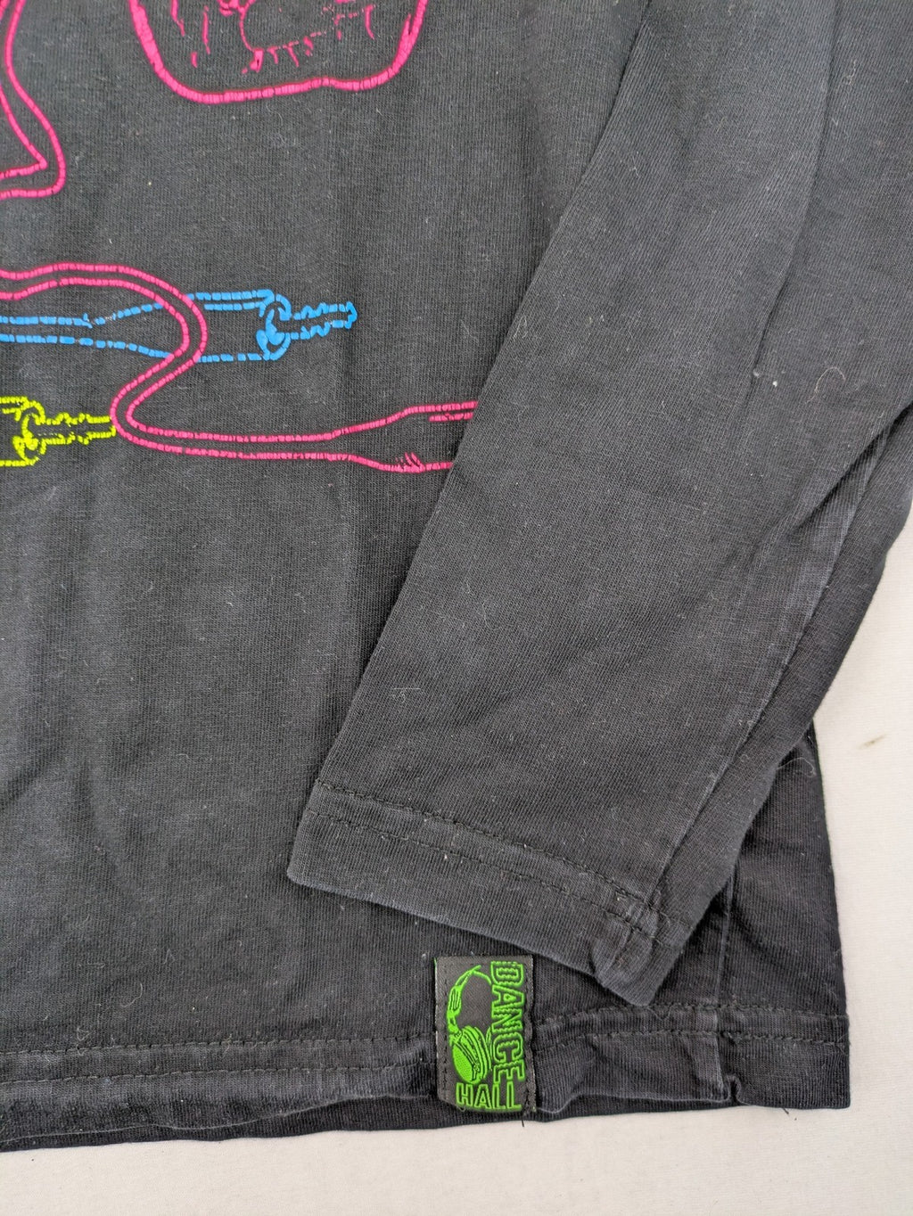 here there pink long sleeve shirt neon skull graphic with headphones and green contrast stitching