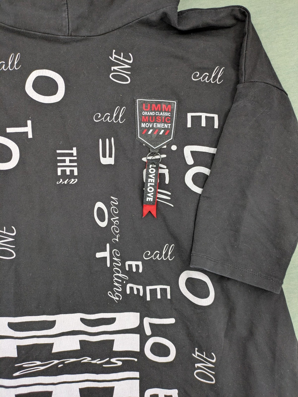 MEGI Collection black hoodie dress with graphic print and asymmetrical high-low hem.