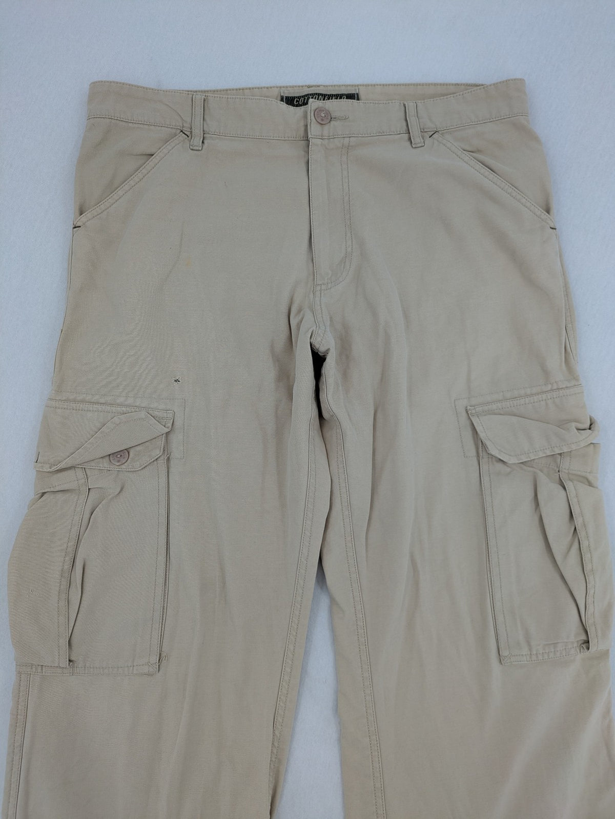 Cottonfield beige cargo pants with multiple pockets and button flaps.