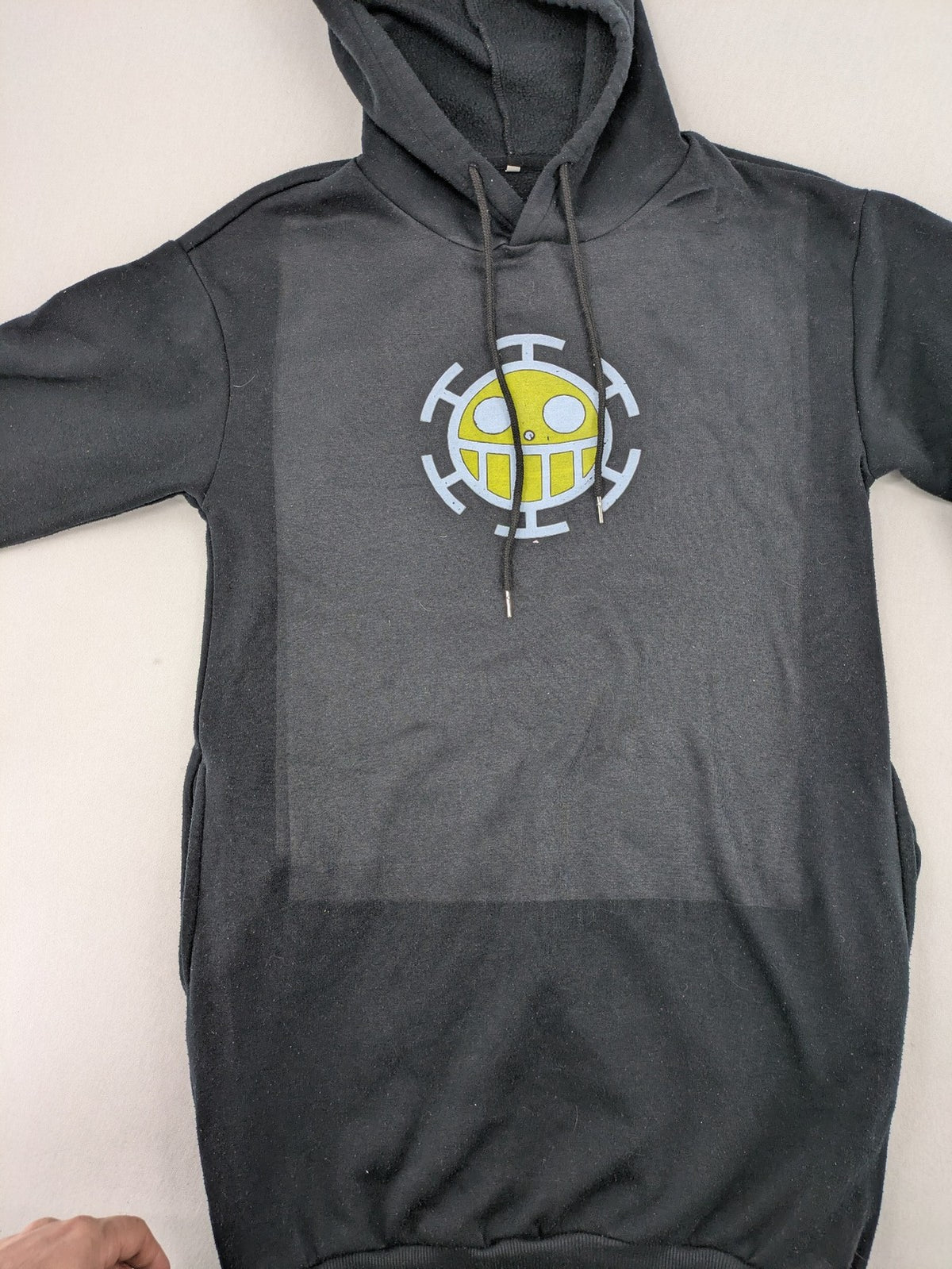 One Piece long hoodie black featuring Trafalgar Law's Jolly-Roger logo and drawstring hood.
