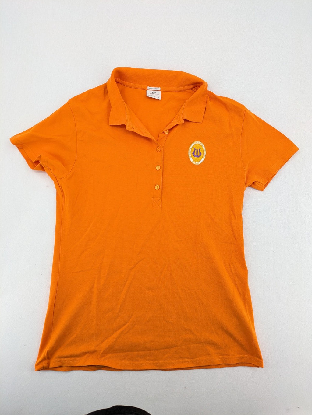 Teejays orange polo shirt with embroidered logo, classic collar, and button placket.