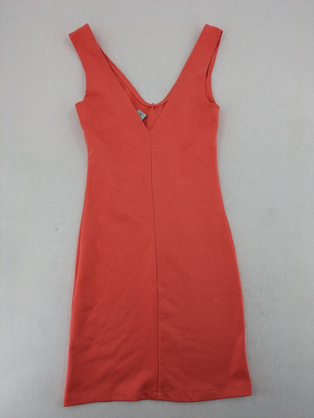Zebra orange bodycon mini dress with deep V-neck and sleeveless design.