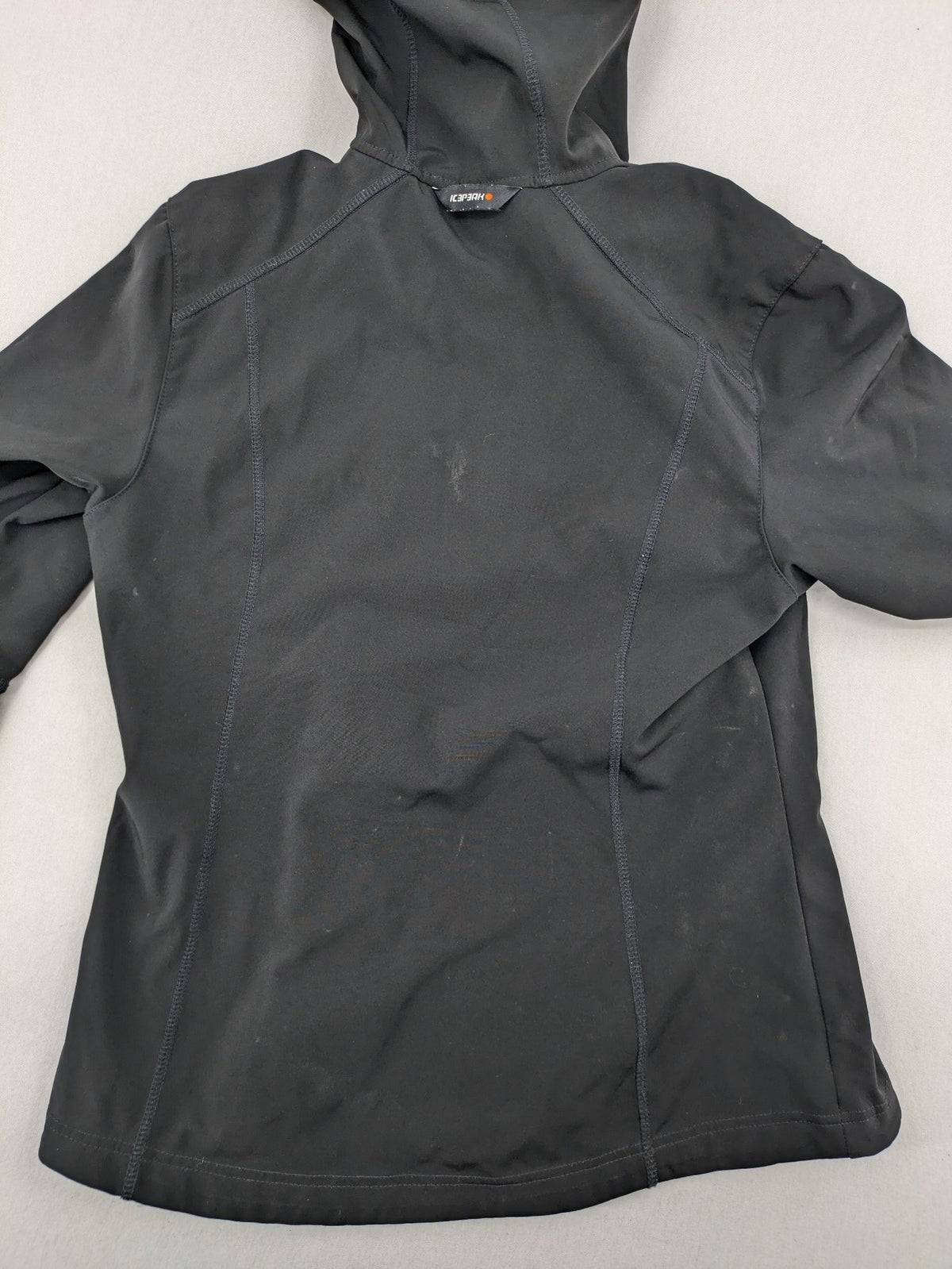 Icepeak black softshell jacket with fleece lining, adjustable hood, and zippered pockets.