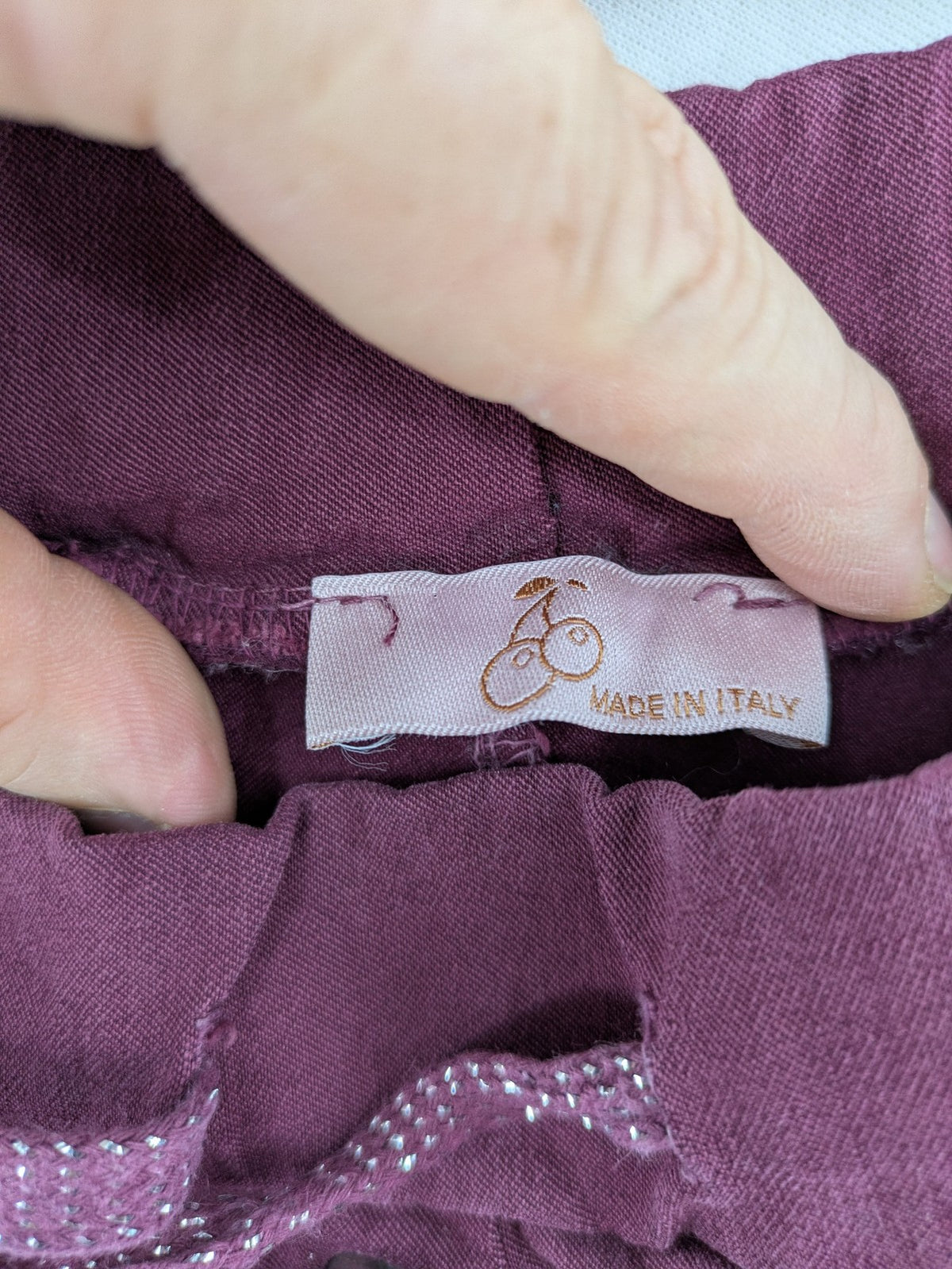 Pink Cherry pants pink stretchy fabric with decorative buttons and elastic waistband.